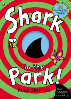 Cover shows red and green concentric circles into the centre of the book where there is a blue circle and a black shark fin. The title "Shark in the Park" is written in bold white text. 