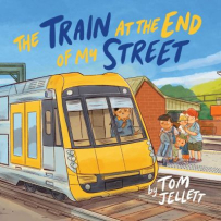 The cover shows a train station with a yellow train pulled up as a family waits on the platform. The title “The Train at the End of My Street” is written in yellow and blue at the top.